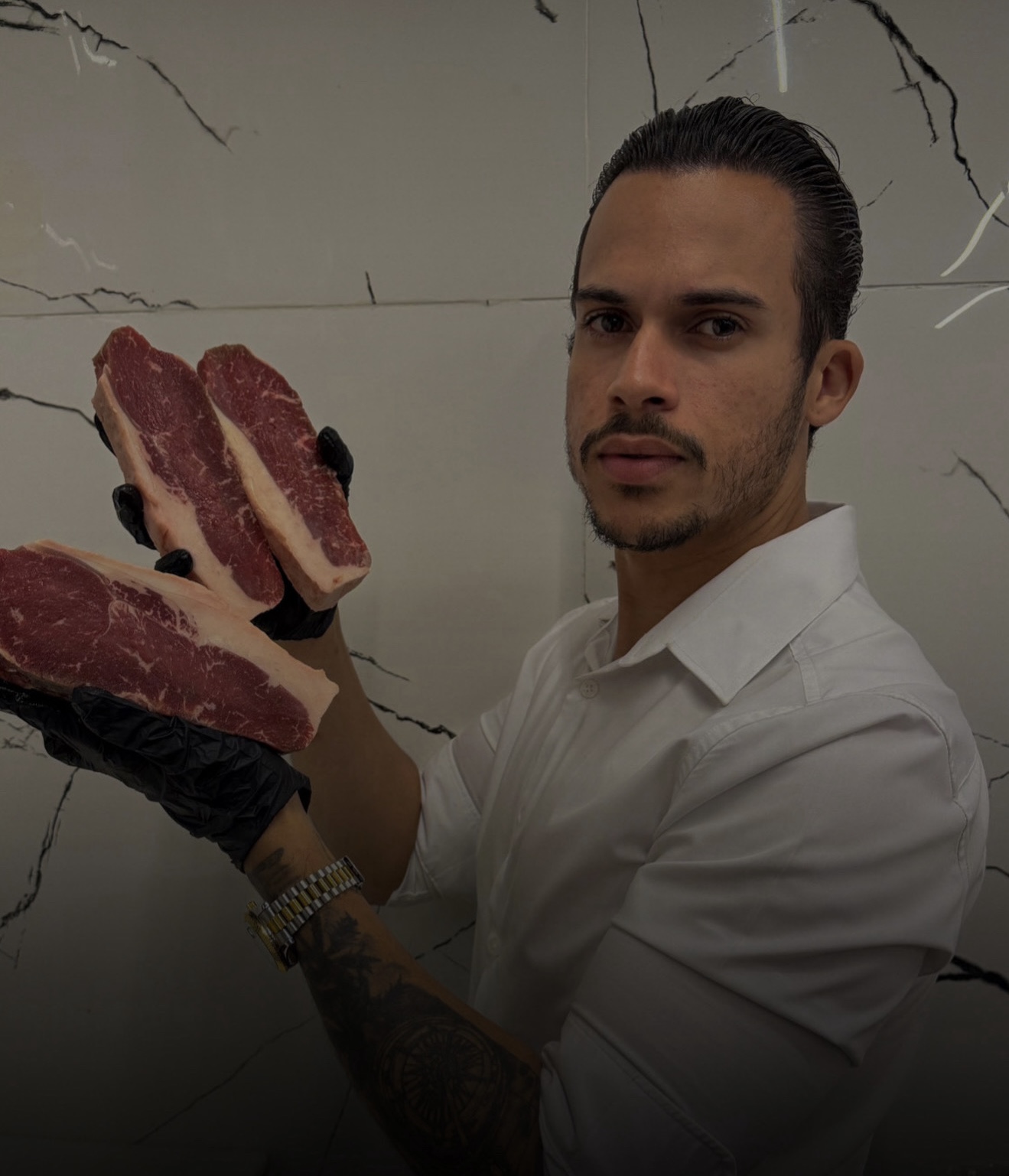 Wéricles Silva segurando cortes de carne no açougue