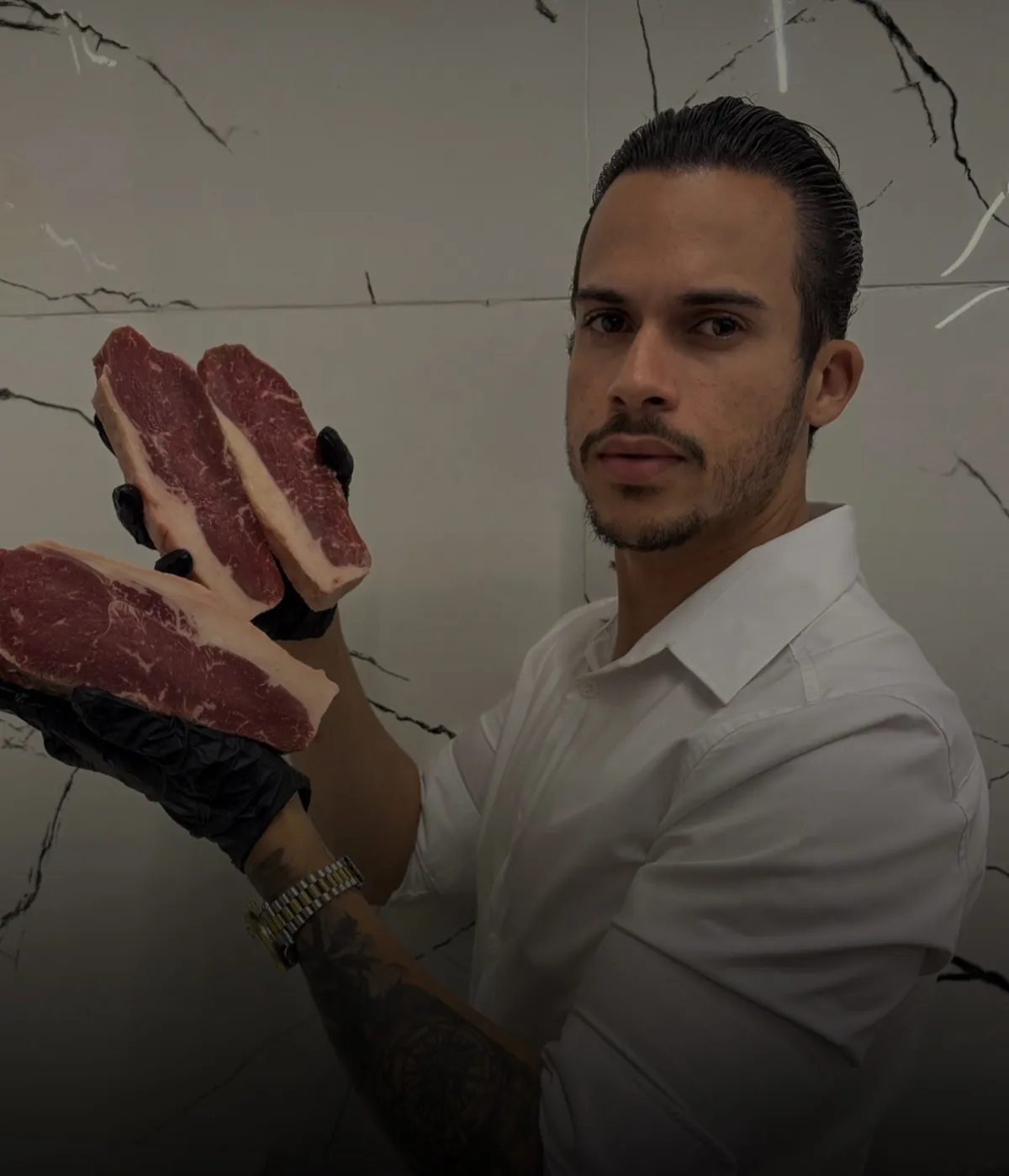 Wéricles Silva segurando cortes de carne no açougue